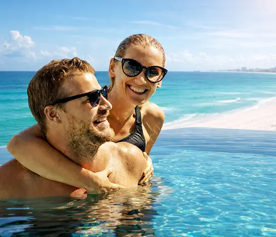 Couple enjoying crystal-clear tropical pool water on vacation day